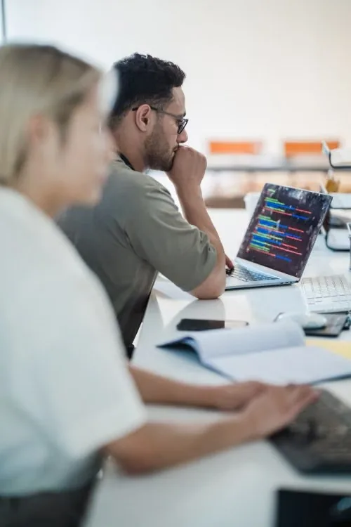Engineers reviewing code on a laptop